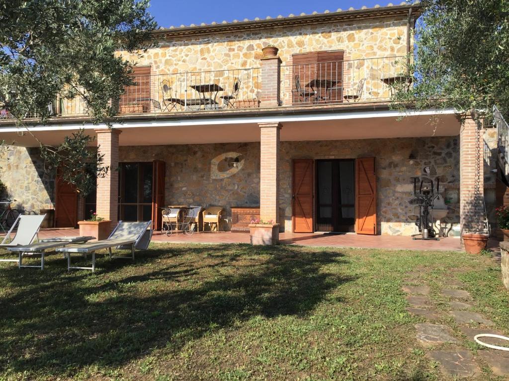 a stone house with a patio and a yard at casa Anna De Croy in Magliano in Toscana