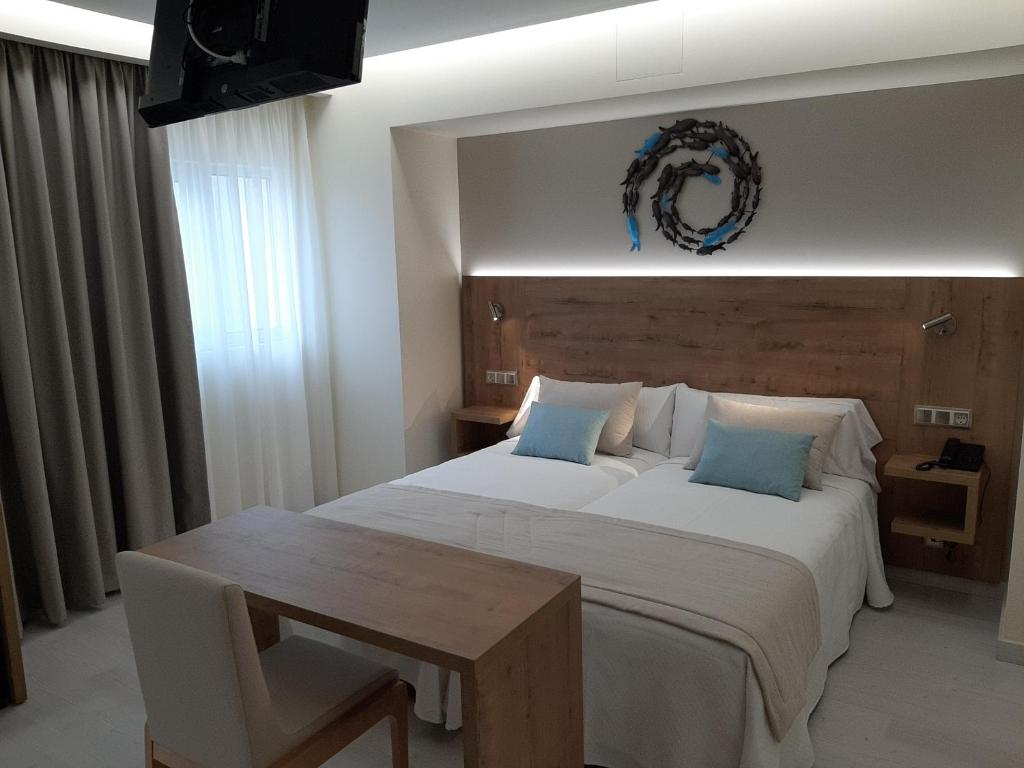 A bed or beds in a room at Hotel Boutique O Náutico Laxe
