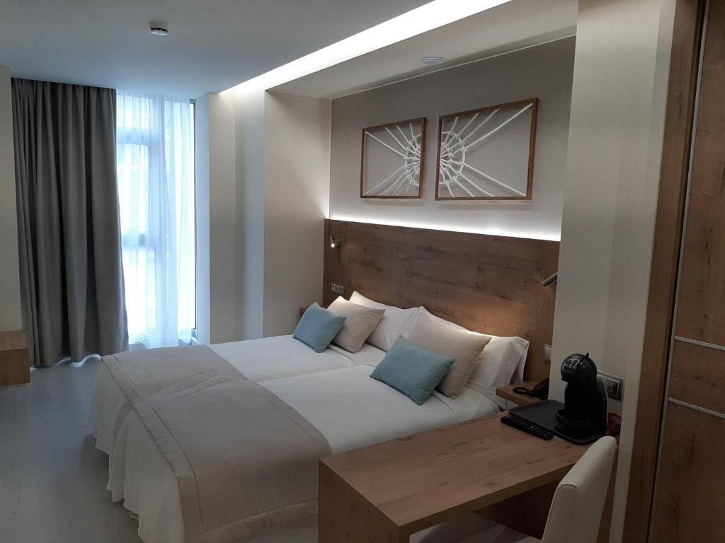 A bed or beds in a room at Hotel Boutique O Náutico Laxe