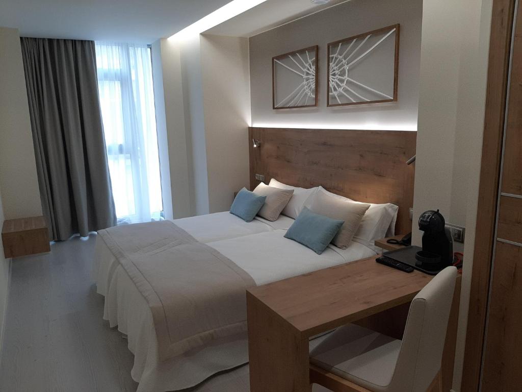 A bed or beds in a room at Hotel Boutique O Náutico Laxe