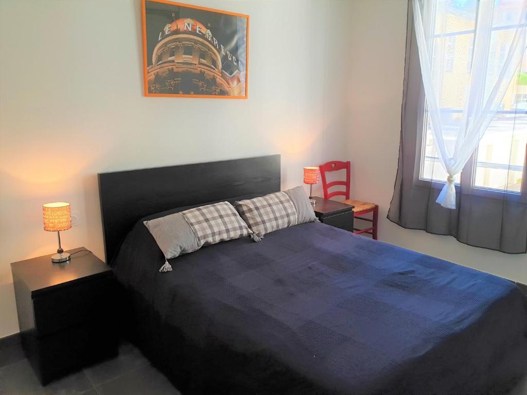 une chambre avec un grand lit avec une couverture bleue dans l'établissement LE 43 NICE PORT, à Nice