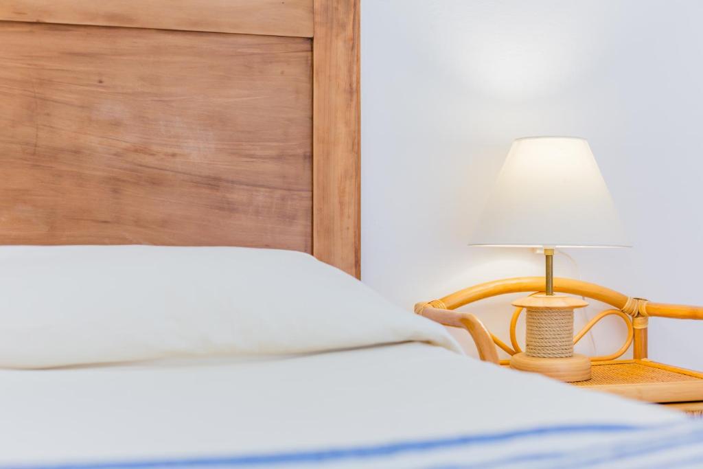 a bedroom with a bed and a lamp on a table at Four Rooms in Carloforte