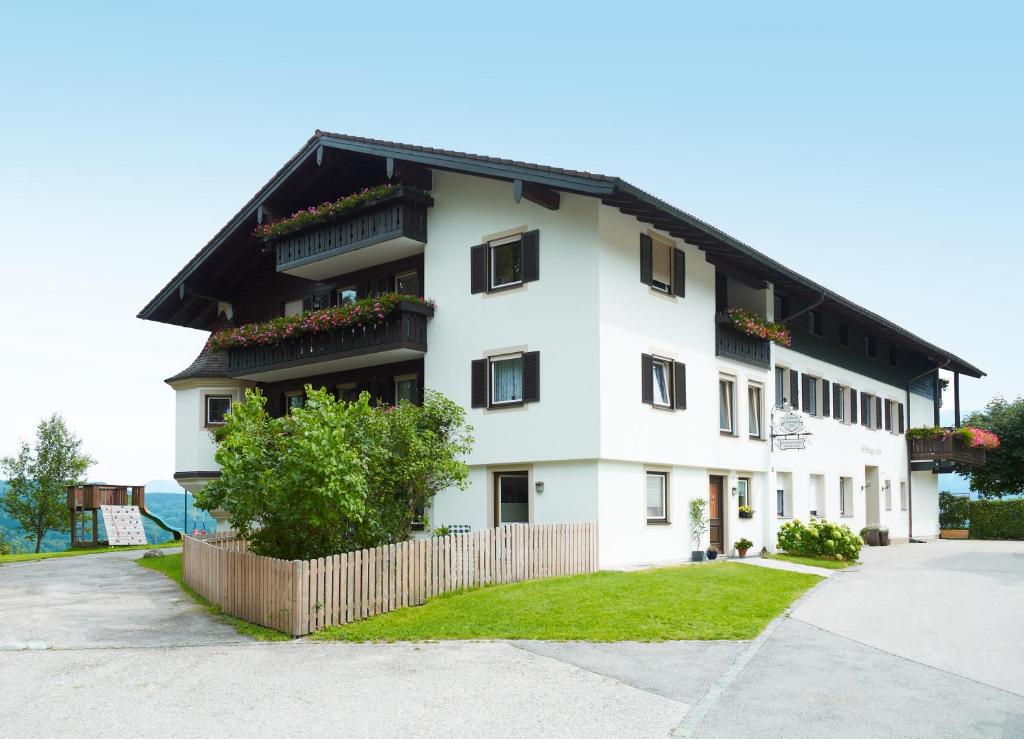 un bâtiment blanc avec un toit noir dans l'établissement Hölbinger Alm - Apartments, à Anger