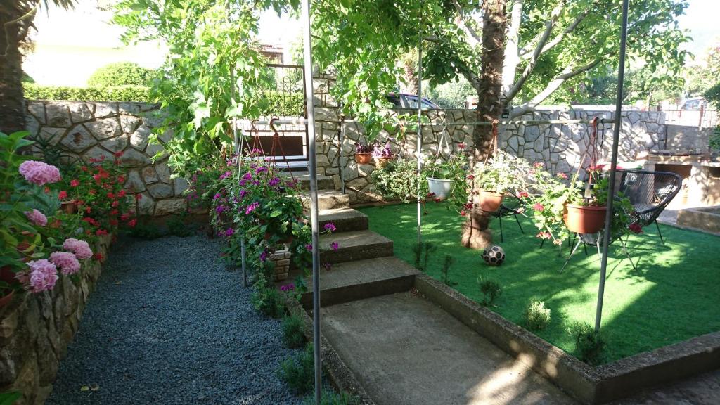 un jardín con macetas y una pared de piedra. en Ela Cres, en Cres