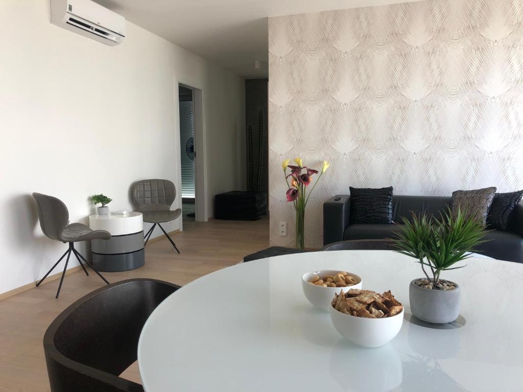 een woonkamer met een witte tafel en stoelen bij 7th Heaven Apartments in Brno