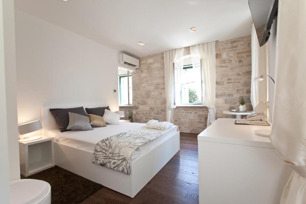 Habitación blanca con cama y baño. en Speruna Luxury Inn, en Split