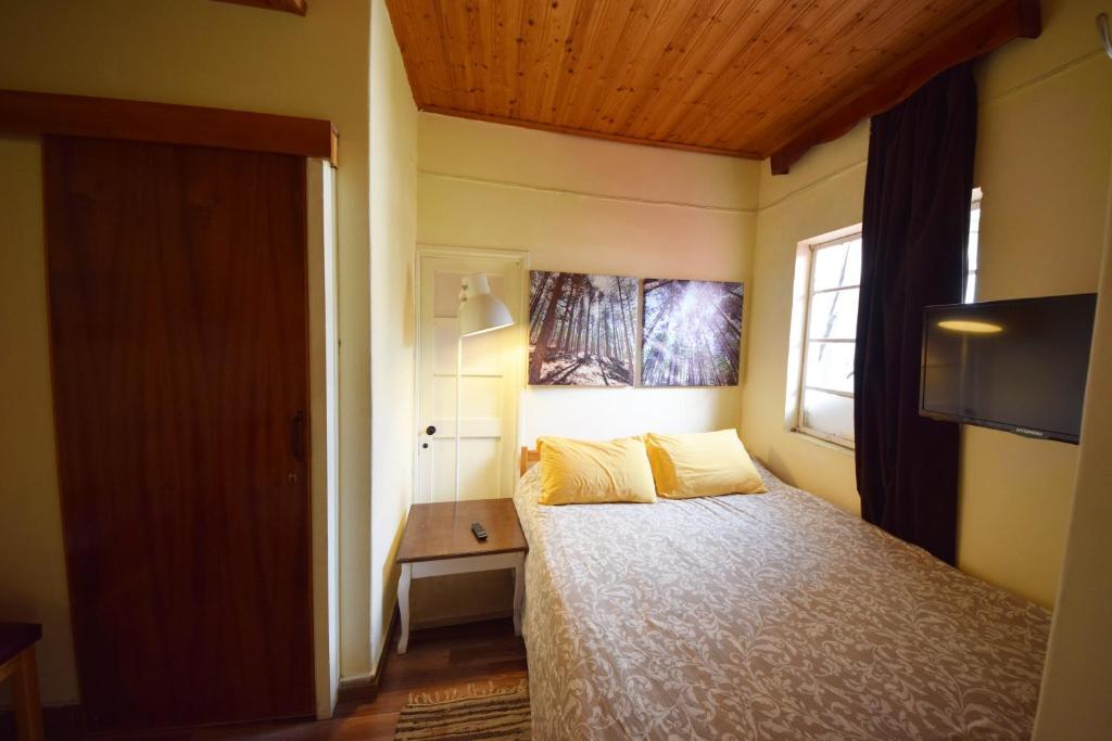a bedroom with a bed with yellow pillows and a window at Christys Palace Hotel in Pedoulas