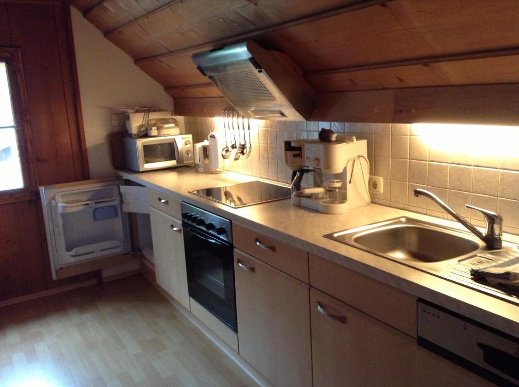 a kitchen with a sink and a microwave at Appartements direkt am See in Grundlsee