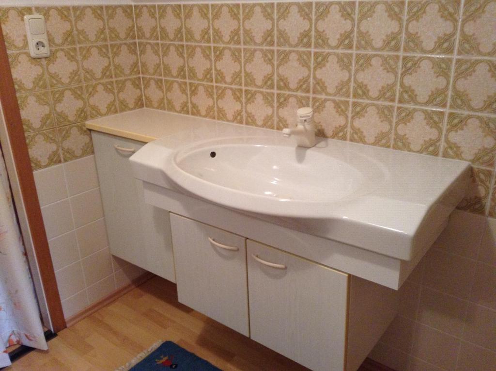 a bathroom with a white sink in a room at Appartements direkt am See in Grundlsee