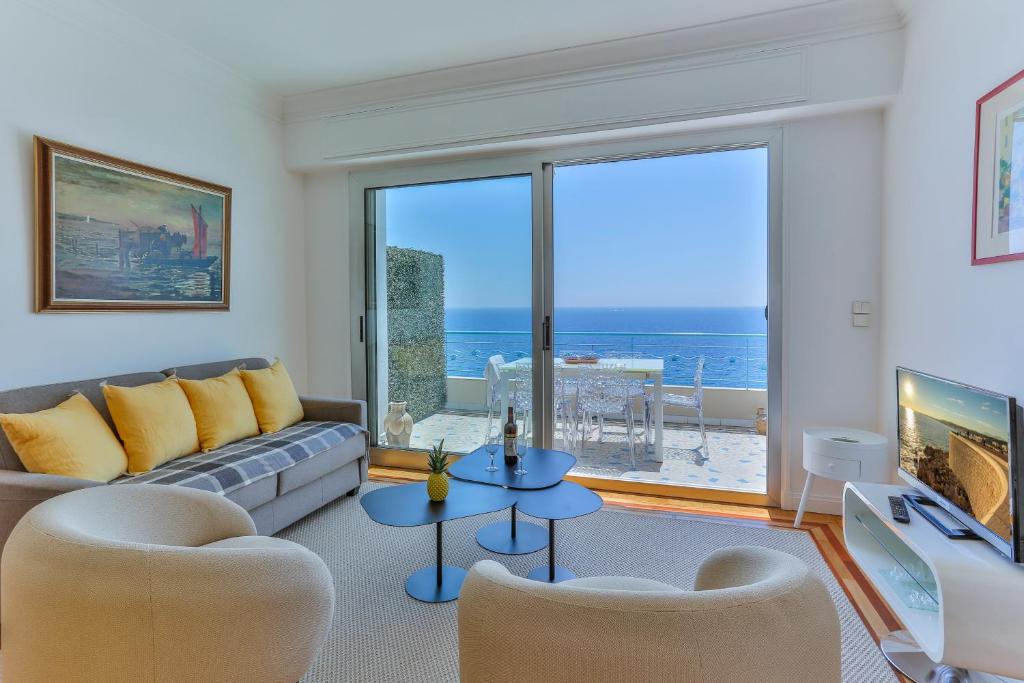 un salon avec un canapé et une vue sur l'océan dans l'établissement Maison Bianchi - 91 Promenade des Anglais, à Nice