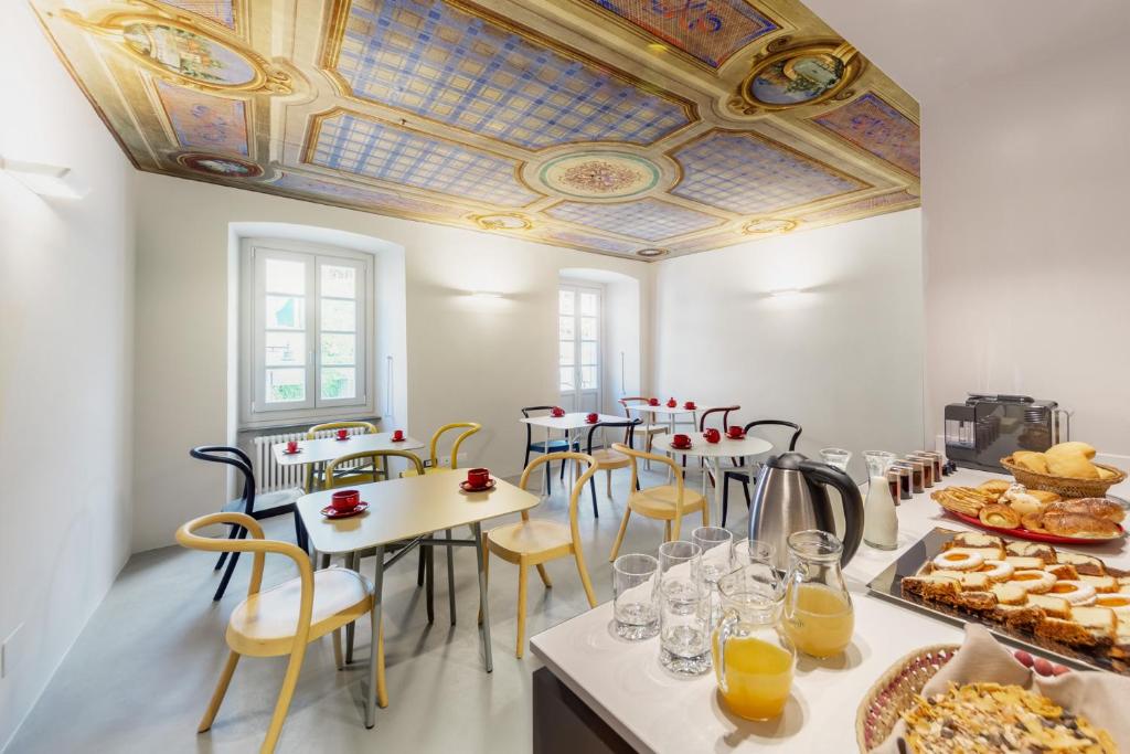 Pokój ze stołami i krzesłami oraz kasetonowym sufitem w obiekcie Maison Alliod w mieście Saint Vincent