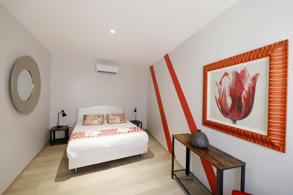 a bedroom with a bed and a painting on the wall at Le Porta 5 in Albi