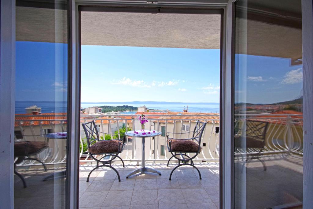 einen Balkon mit 2 Stühlen und einem Tisch mit Aussicht in der Unterkunft Makarska sea view rooms in Makarska