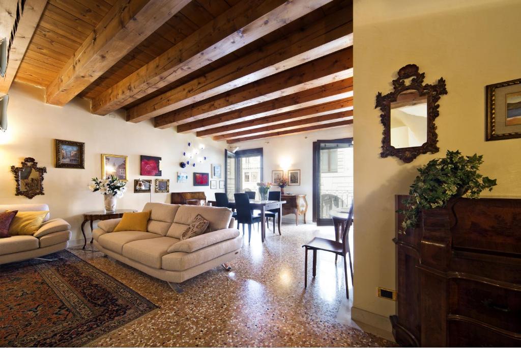 ein Wohnzimmer mit Sofas und ein Esszimmer in der Unterkunft PadovaResidence Apartments - vista Piazza delle Erbe e Palazzo della Ragione in Padua