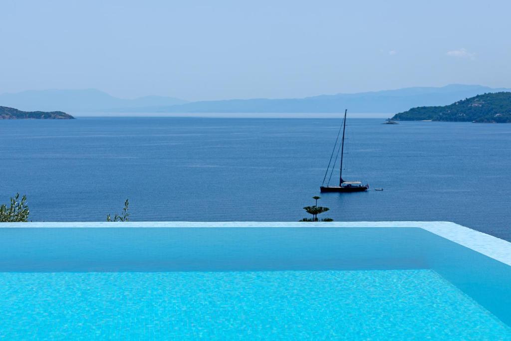 una piscina con un velero en el agua en Villa K, en Skiathos