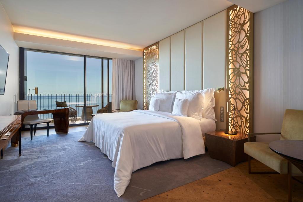 a bedroom with a large white bed and a large window at Savoy Palace - The Leading Hotels of the World - Savoy Signature in Funchal