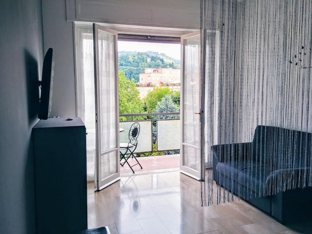 a living room with a couch and a view of a balcony at Appartamento con terrazzo zona ospedale civile in Brescia