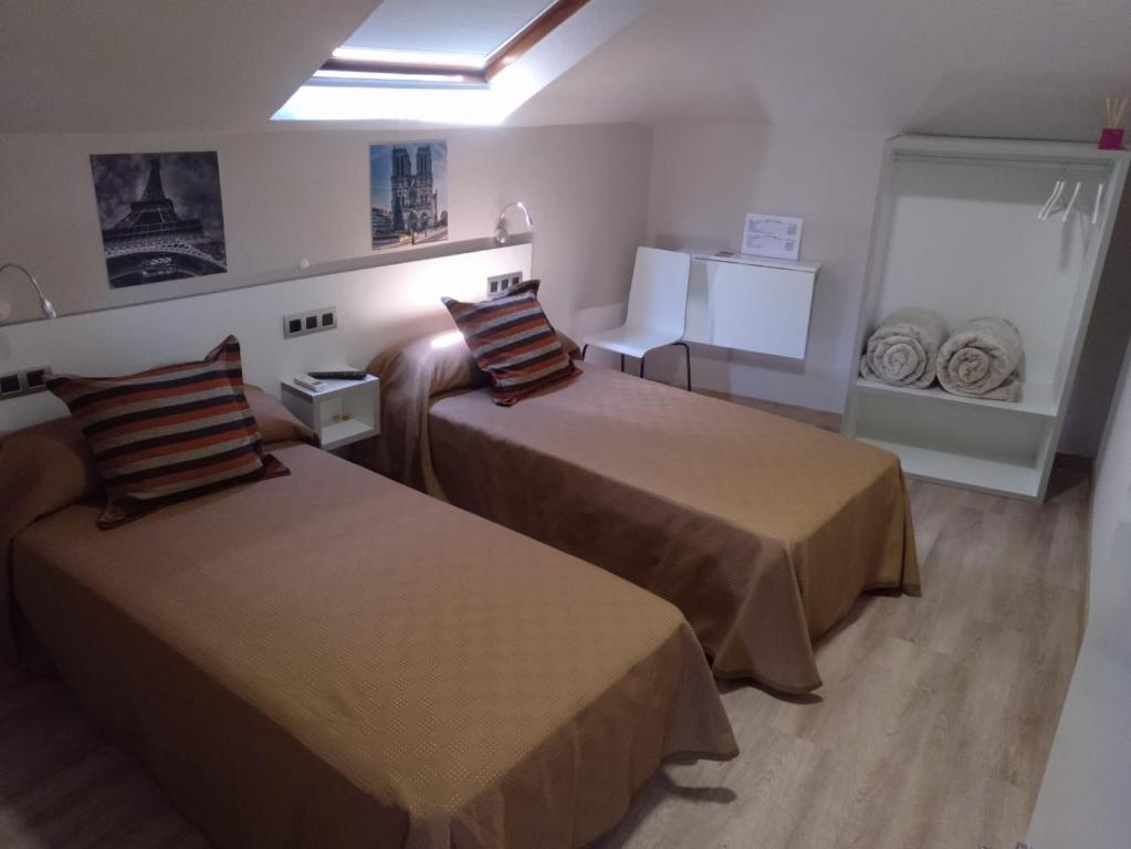 um quarto de hotel com duas camas num quarto em Travesia Rooms em Sarria