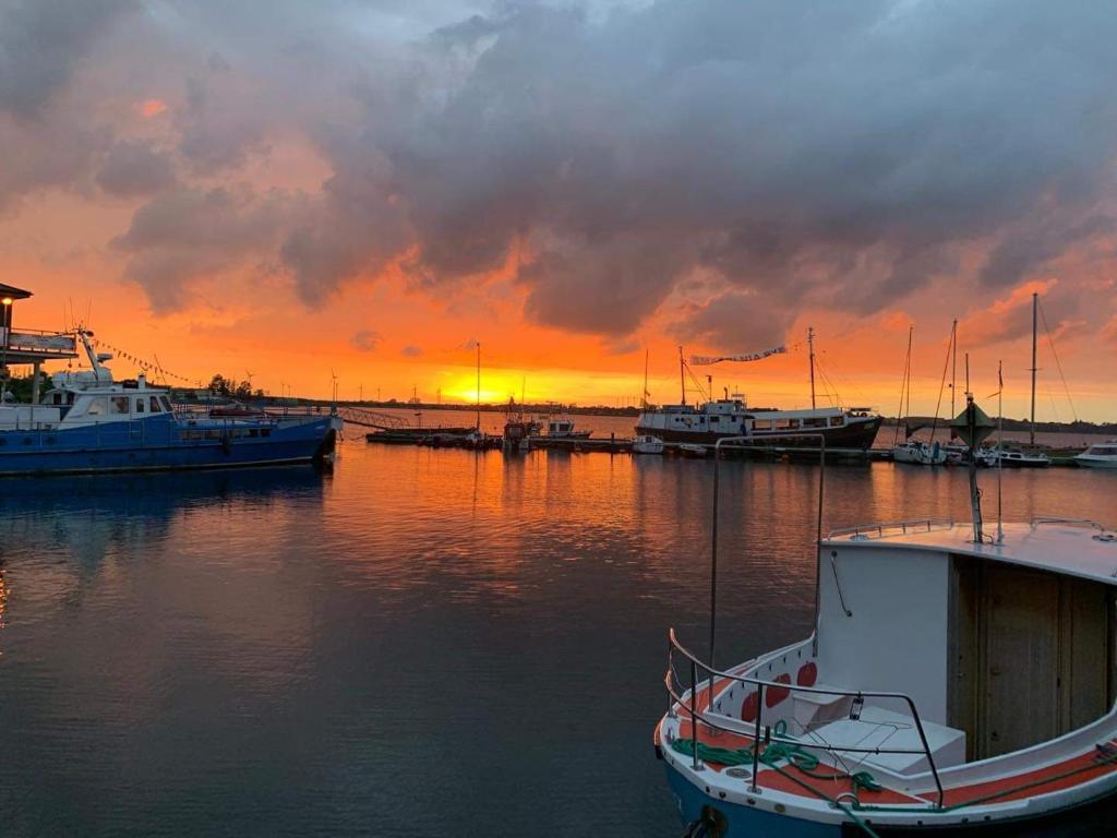 um grupo de barcos ancorados num porto ao pôr-do-sol em PuckApartments em Puck