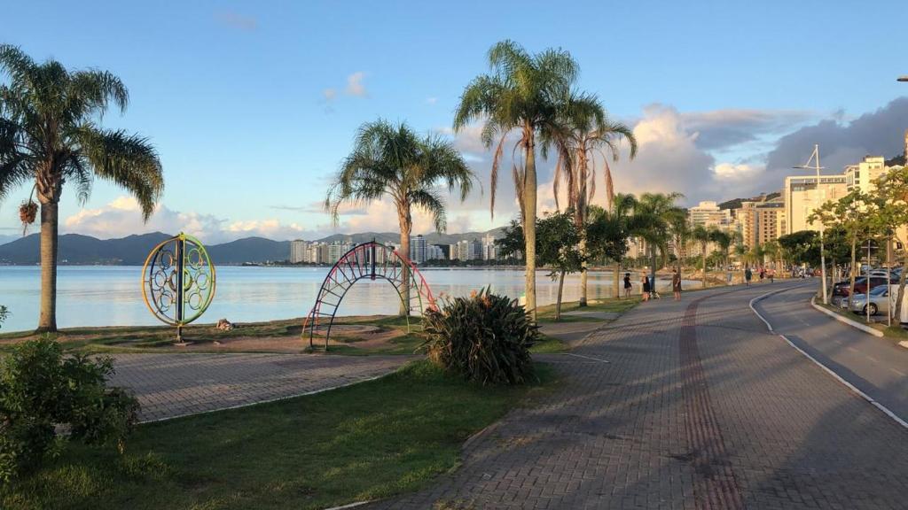 una calle con palmeras y una montaña rusa en Apto aconchegante 100m Shopping Beiramar en Florianópolis