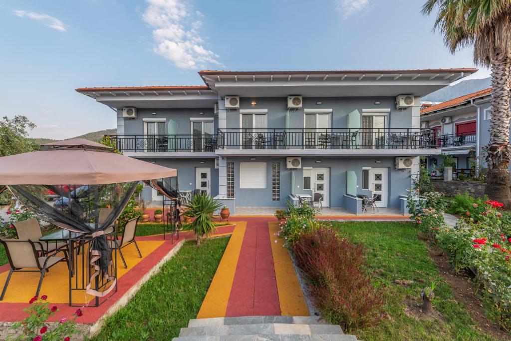 ein Haus mit einem Garten und einer Terrasse in der Unterkunft Katerina Rooms & Apartments in Skala Potamias