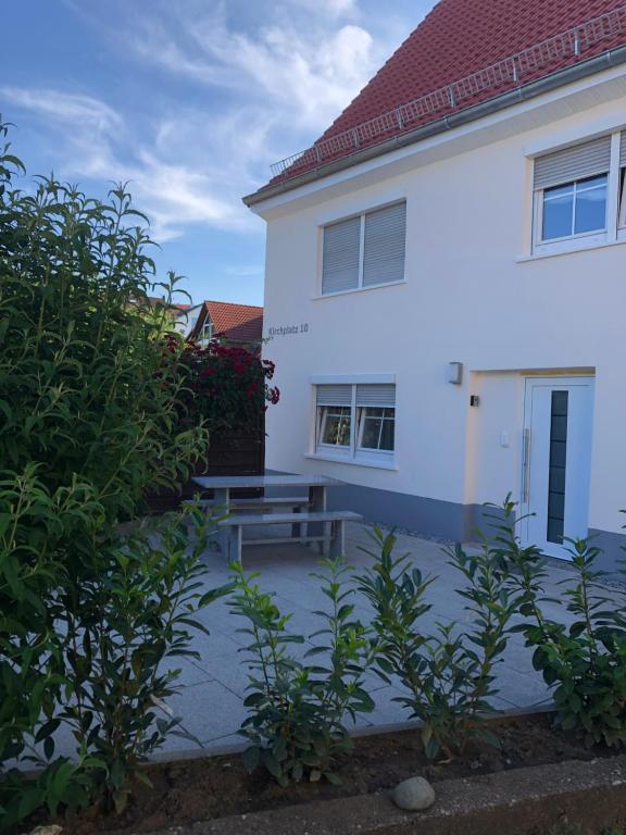 a white house with a picnic table in front of it at Guest Appartements mit 2 getrennten Schlafzimmern für 4 Personen 24h check in in Aalen