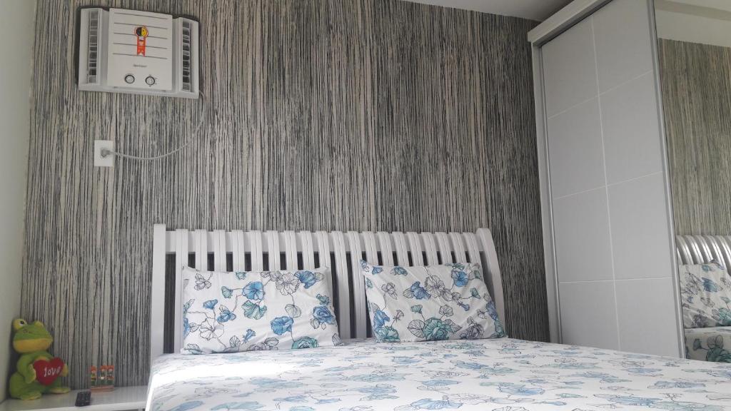 a bedroom with a bed with blue and white pillows at APTº NOVO NO SANTA LÚCIA in Aracaju