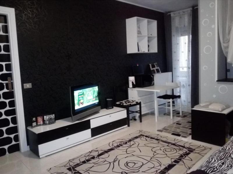 a living room with a tv on a black wall at Appartamento IL PORTO in Martinsicuro