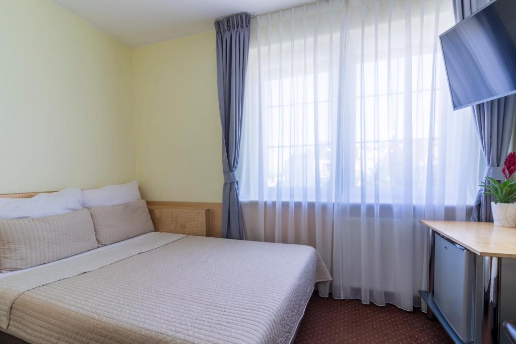 niewielka sypialnia z łóżkiem i oknem w obiekcie Villa Aida pokoje gościnne w Gdańsku