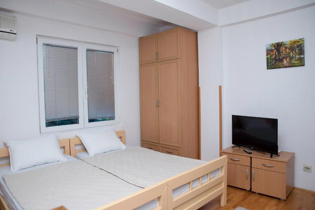 a bedroom with a bed and a tv on a cabinet at Central Apartment Ohrid in Ohrid