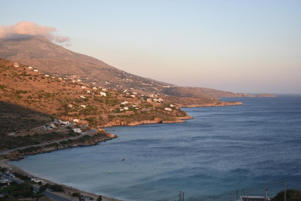 a town on a hill next to the water at Monolithos Villas in Kipri