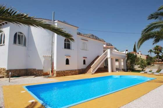 a villa with a swimming pool in front of a house at Villa Bozena in Denia