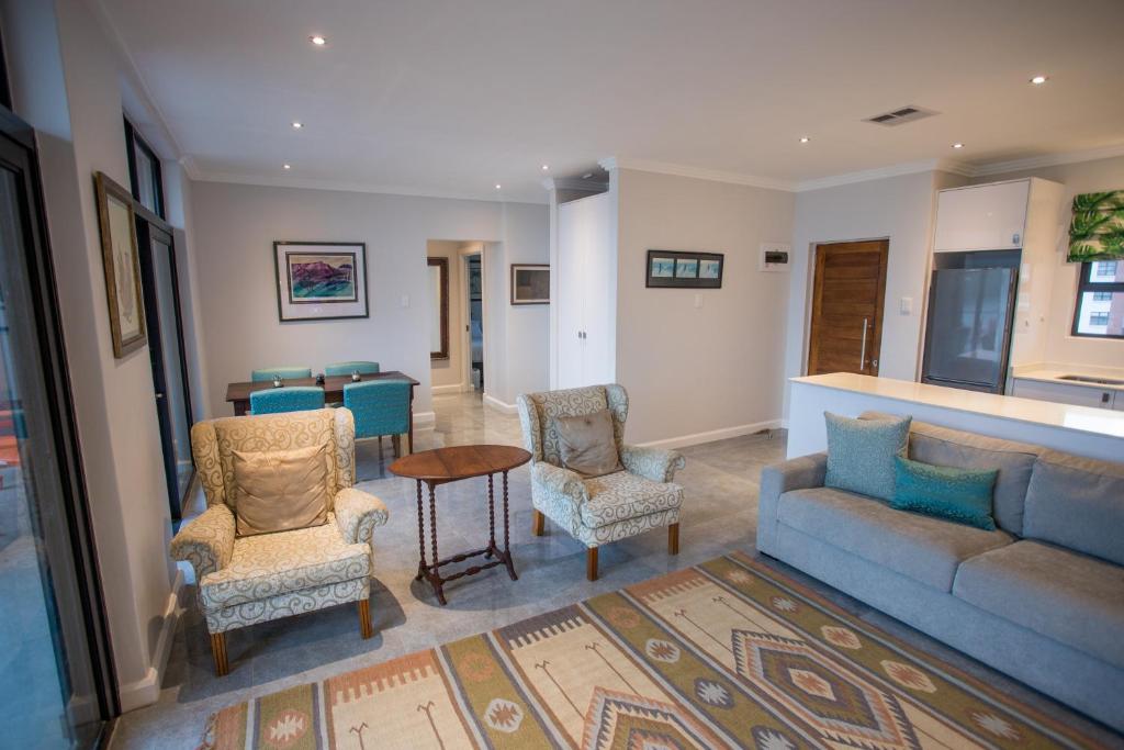 a living room with a couch and chairs and a table at Stay at The Point - Penthouse Plush Perfection in Durban