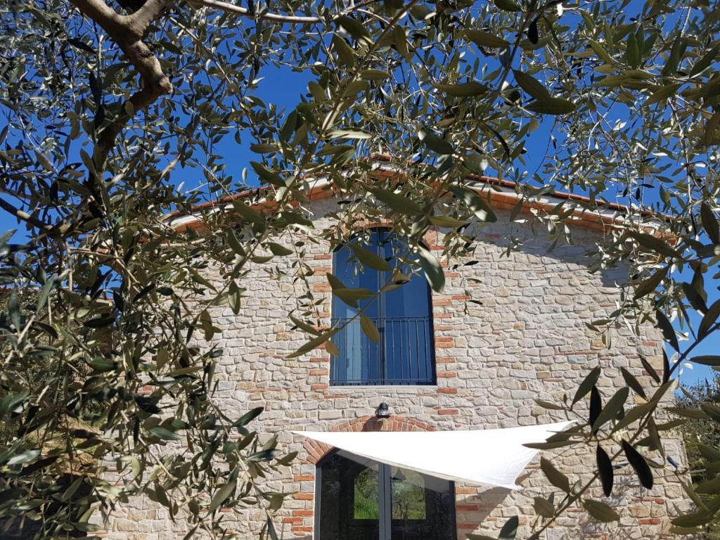 a brick building with a window and a tree at Il Fienile de La Cavallina in Larciano