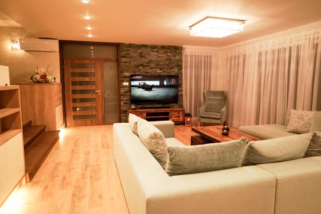a living room with a white couch and a television at Luxury Villa in Moravany nad Váhom