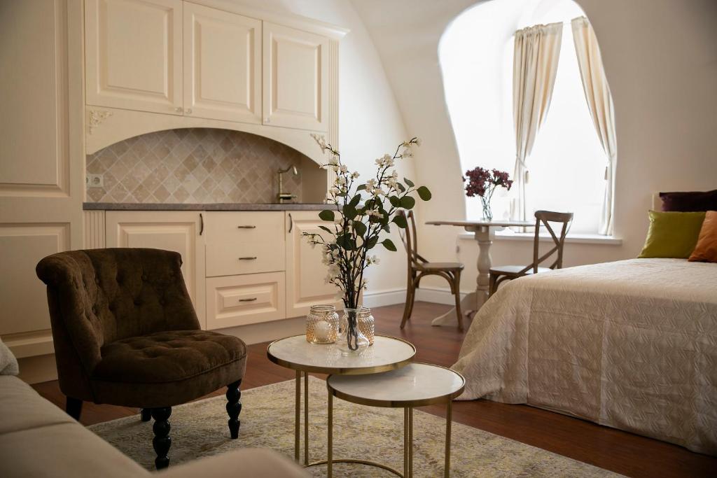 a living room with a bed and a table and a chair at Heart of OLD TOWN - St. Ann apartment in Vilnius
