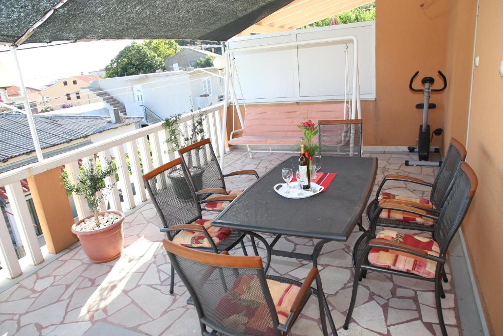 a patio with a table and chairs on a balcony at Apartman Luna in Dugi Rat
