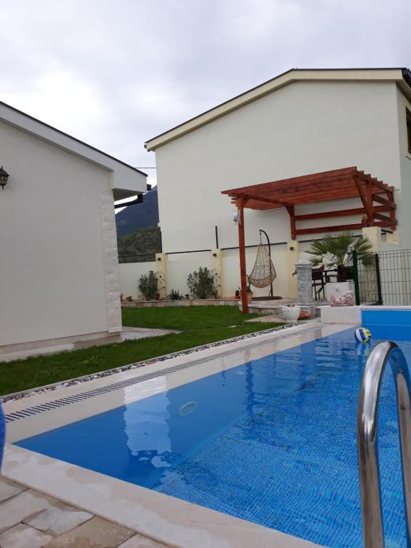 a swimming pool in front of a house at Vila Pelinovo in Kotor