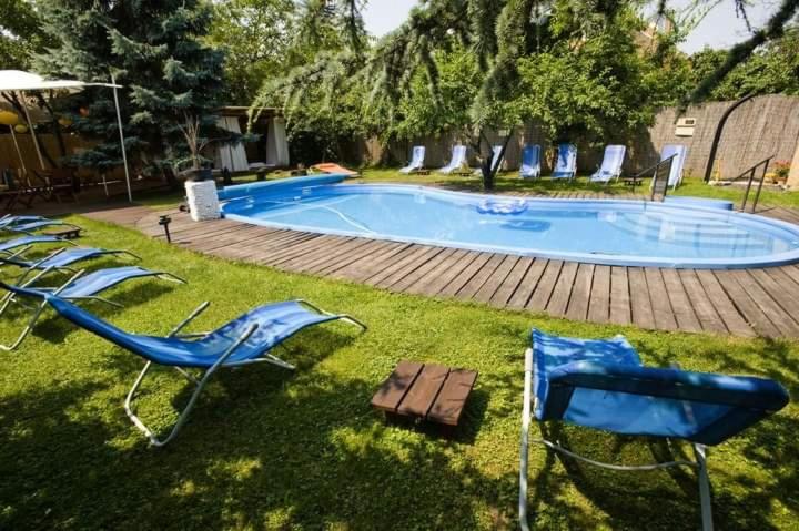um grupo de cadeiras sentadas ao lado de uma piscina em Buddha Residence em Sopron