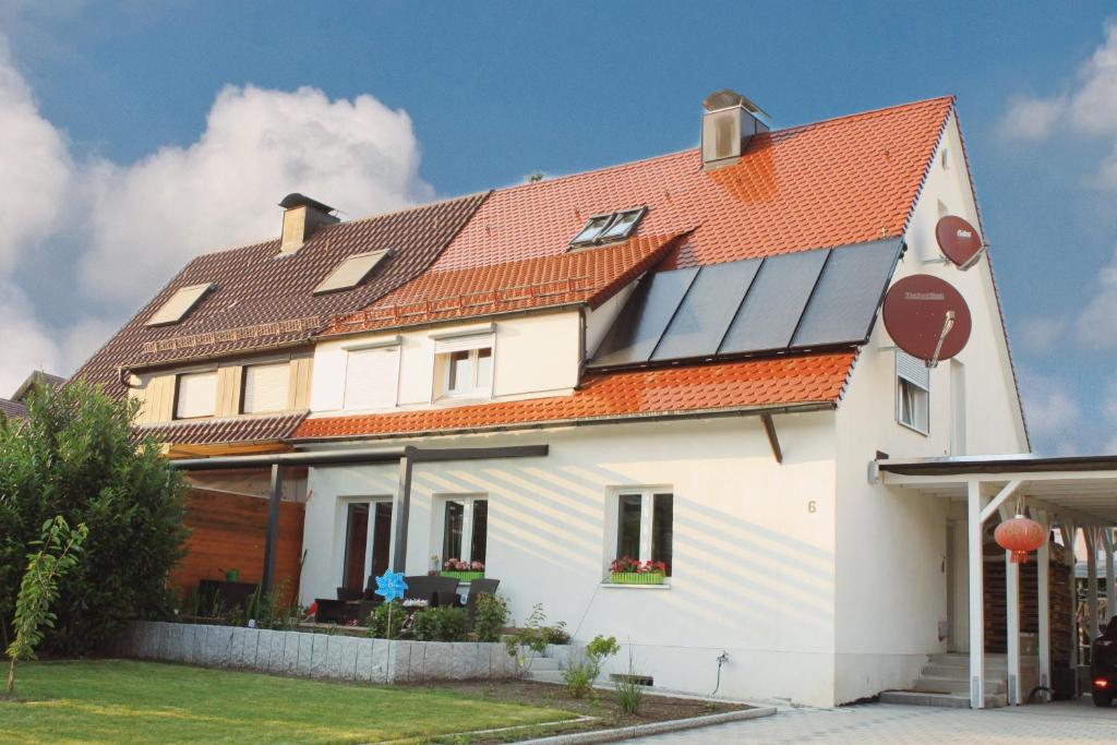 a house with solar panels on the roof at Schöne Zeit 2 rooms apartment with kitchen in Friedrichshafen