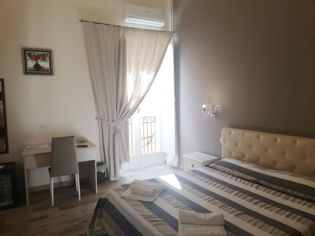 a bedroom with a bed and a window and a desk at B&B The Tower in Tropea