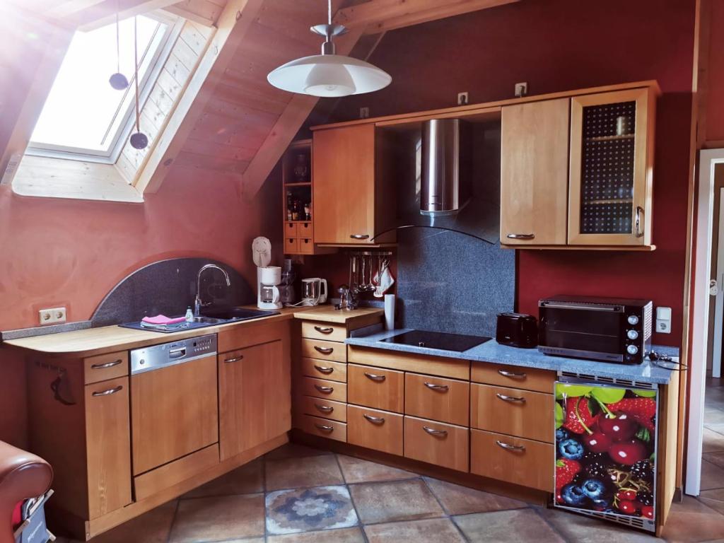 a kitchen with wooden cabinets and a stove top oven at Ziegeleihof inmitten von Wiesen und Wäldern in Degenershausen