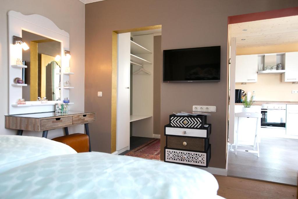 een slaapkamer met een bed en een tv aan de muur bij CasaKarita in Forstern
