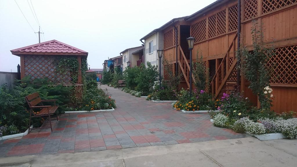a courtyard with a pathway with flowers and a gazebo at Dacha u Morya in Andreyevka
