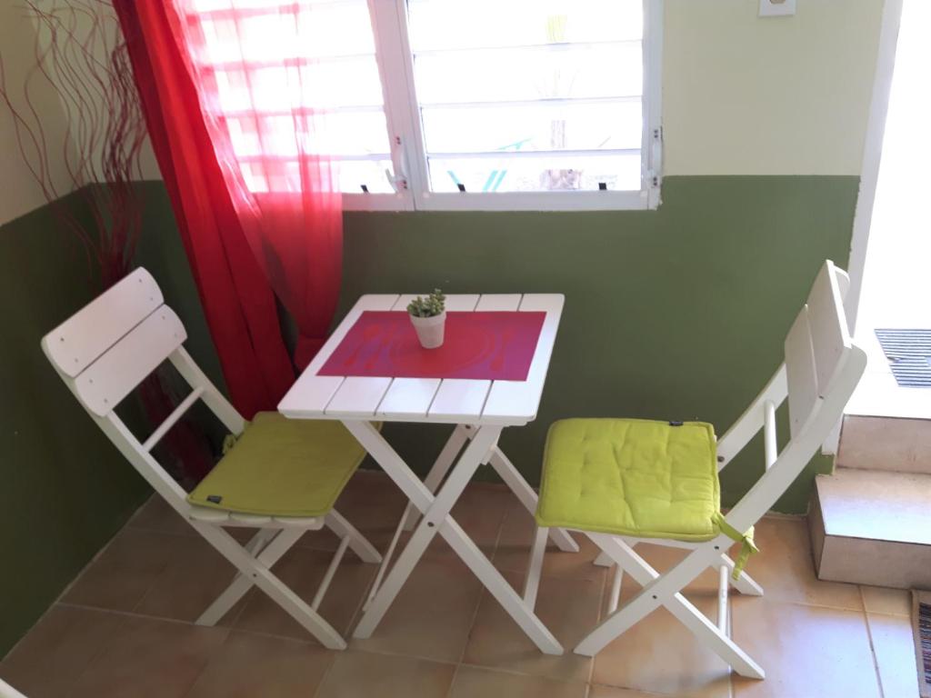 a small table and chairs in a room with a window at SXM Spotters Paradise in Lowlands