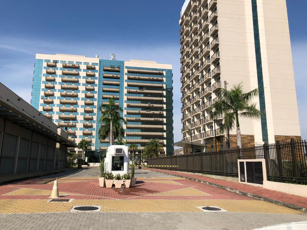 a white car parked in front of some buildings at Flat Caxias Multisuites in Duque de Caxias