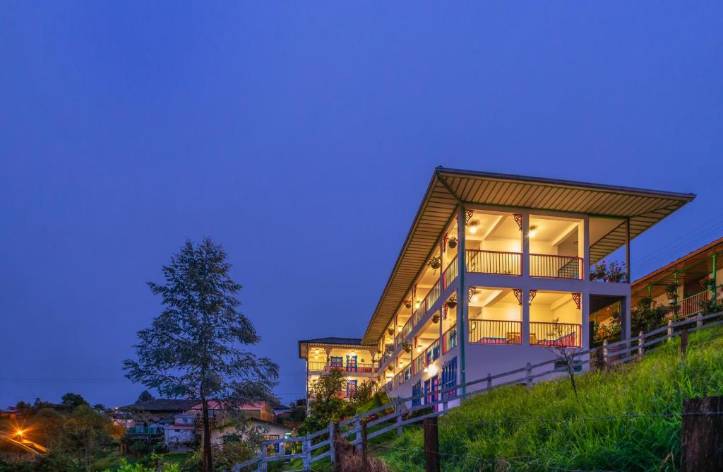 une maison au sommet d'une colline la nuit dans l'établissement Hotel El Jardin, à Salento