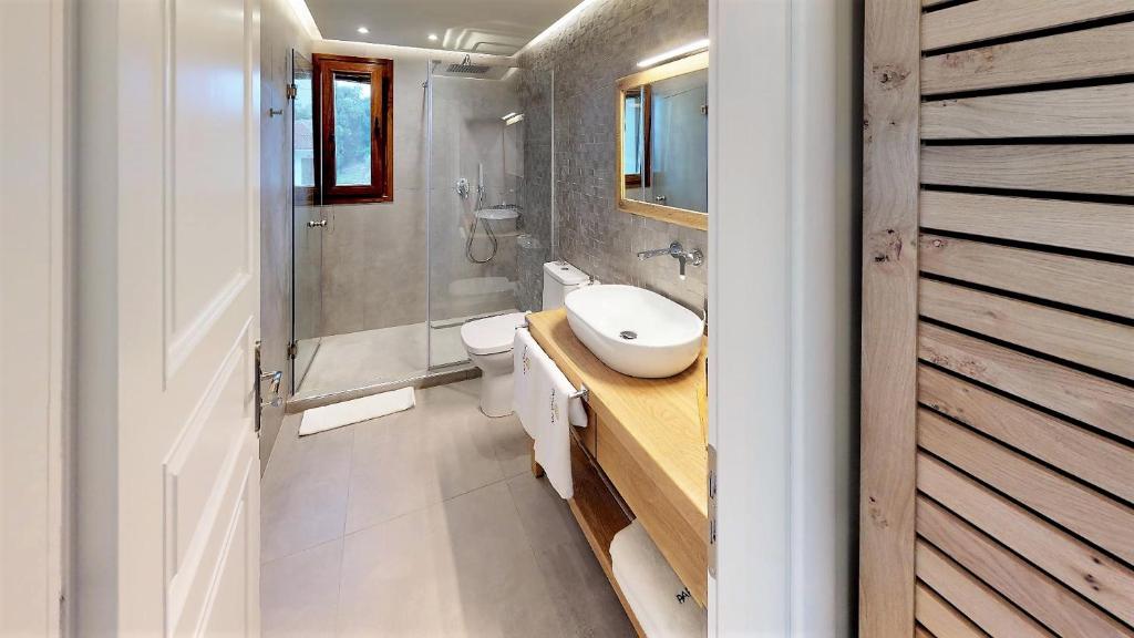 a bathroom with a sink and a toilet and a shower at Parga Inn Suites in Parga