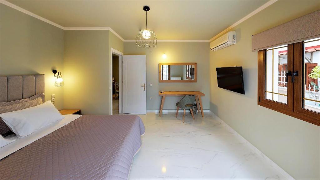 a bedroom with a bed and a desk in it at Parga Inn Suites in Parga