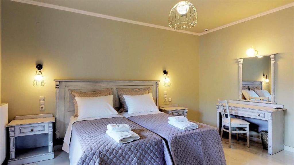 a bedroom with a bed and a desk and a mirror at Parga Inn Suites in Parga